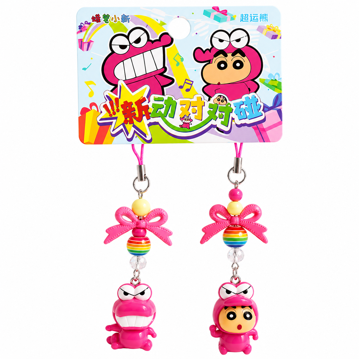Two colorful cartoon character keychains with a decorative card in the background.